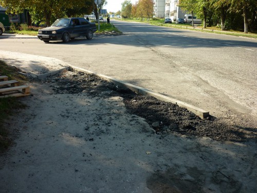 только что заасфальтированная дорога и выложенный тротуар