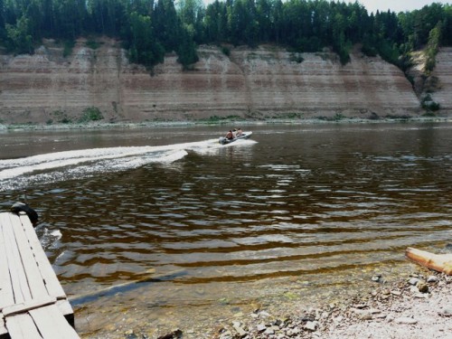 Местные жители на моторных лодках доставляют туристов к самоизливающейся скважине